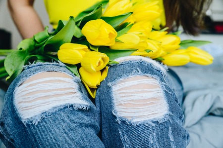 woman hold bouquet of yellow tulips. romantic flowers kneesの写真素材