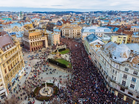 LVIV, UKRAINE - APRIL 6, 2018: Procession with a large cross. The crowd is walking their temple to...