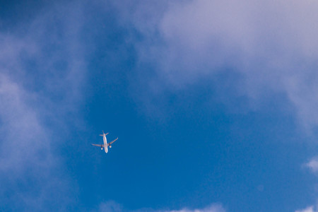 view of plane from ground. travel concept. blue sky with white clouds