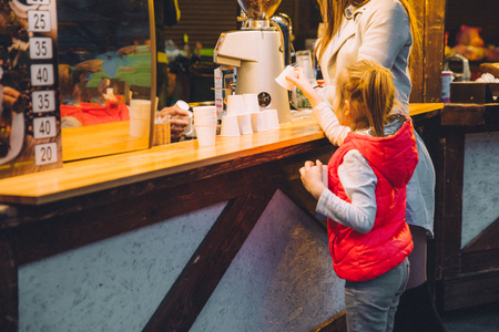 little girl near counter on street food festivalの写真素材