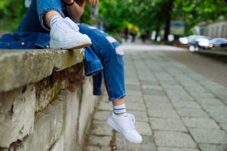 woman sitting on parapet at street. resting after walk. body partの写真素材