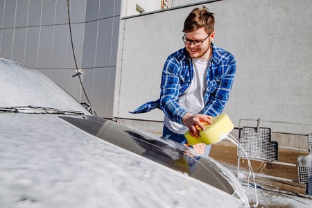 smiling man washing his car. self-service. carwash conceptの写真素材