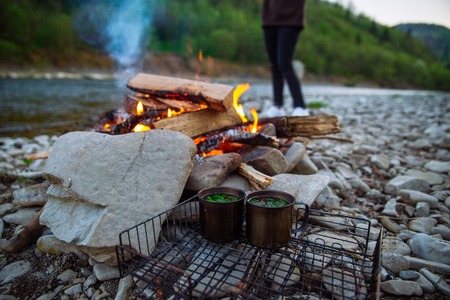 camp fire on riverside in carpathian mountainsの写真素材