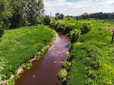 Dirty brown river. pollution concept. green riversideの写真素材