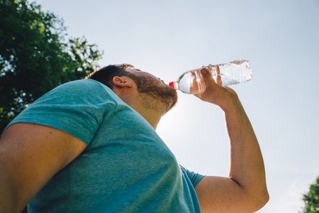 man drinking water in hot summer day. copy space