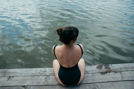 sexy woman legs close up on wooden dock. lake on backgroundの写真素材