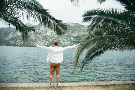 man sitting at seaside with beautiful view. mountains on background. summer time