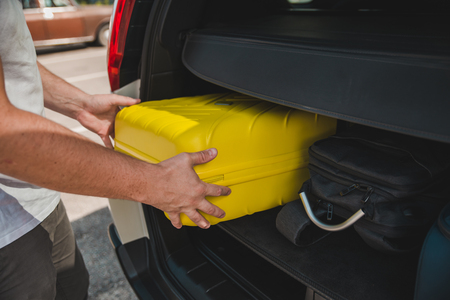 hands load bags in car trunk. car travel conceptの写真素材