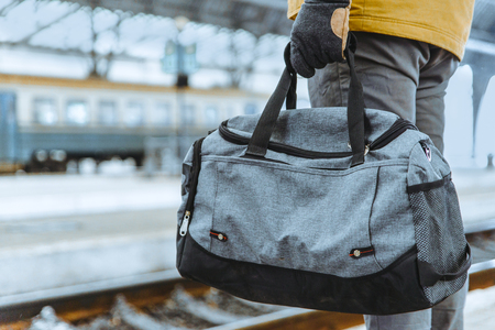 travel concept. man hold bag close up on railway stationの写真素材