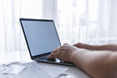 man hands typing on keyboard. laptop with white screen. laptop looks like macbook. copy space
