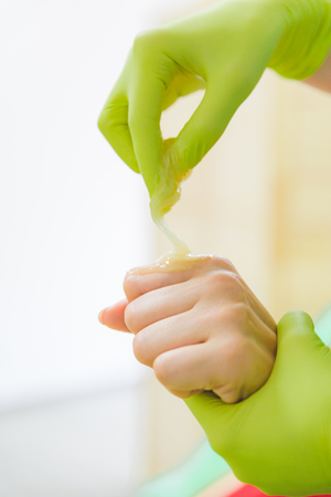woman making sugaring in cosmetic center. epilation beauty concept. hands close upの写真素材
