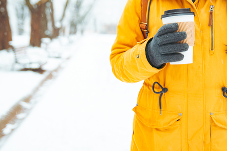 woman holding cup of coffee outside in winter day conceptの写真素材