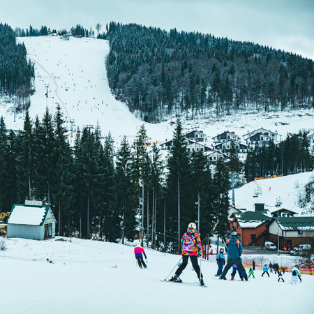BUKOVEL, UKRAINE - December 9, 2018: people skiing from snowed hill. winter sport activity. vacation conceptのeditorial素材