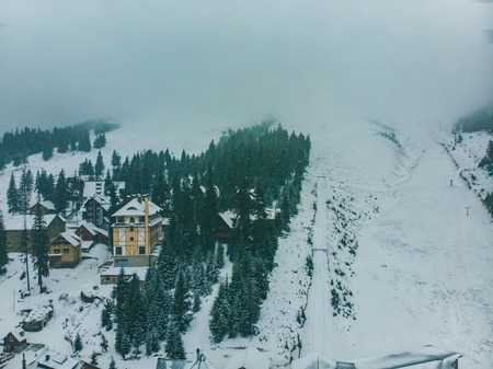 aerial view of small village in snowed mountains. overcast weather. snow stormの写真素材
