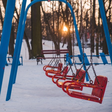 child swings on sunset in city park. nobody