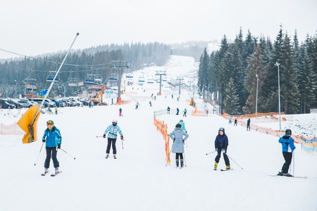 BUKOVEL, UKRAINE - December 9, 2018: people skiing from snowed hill. winter sport activity. vacation...