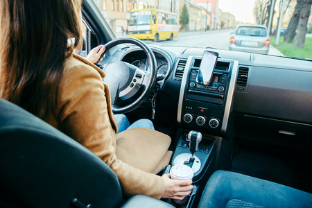 woman driving car and drinking coffee
