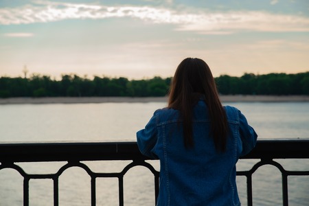woman looking on sunrise over the river. calm placeの写真素材