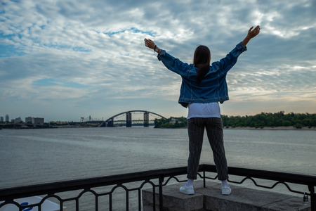 woman looking on sunrise over the river. hands rise up