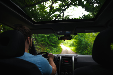 man driving suv car by forest trail road. adventure timeの写真素材