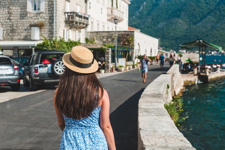 woman walking by city streets near sea. summer vacation. travel conceptの写真素材