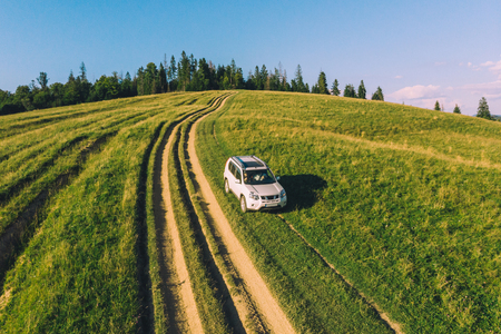 white suv car in mountains at path trail on sunset. aerial viewの写真素材