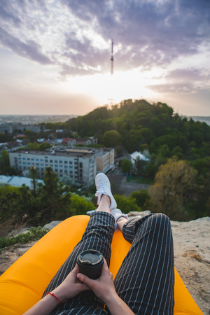 woman looking at sunset over city. sitting on the peakの写真素材
