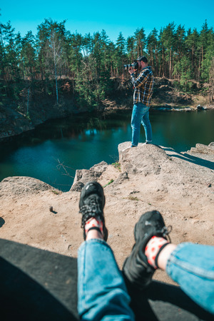 woman sitting in car trunk. man taking picture at professional camera. lake on background. travel conceptの写真素材