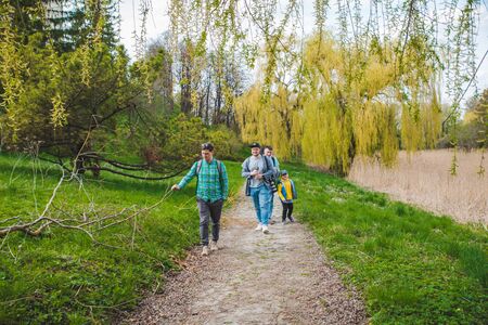 OLESKO, UKRAINE - April 20, 2019: young group of people with kids walking by nature park. spring sunny dayのeditorial素材