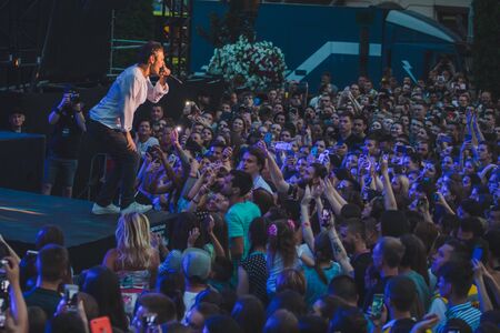 LVIV, UKRAINE - June 18, 2019: rock band singer on stage with microphone crowd around stage shooting on phones. music festのeditorial素材
