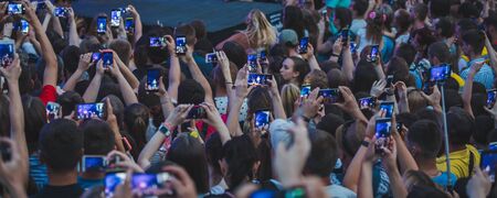 LVIV, UKRAINE - June 18, 2019: rock band singer on stage with microphone crowd around stage shooting on phones. music festのeditorial素材