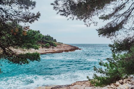 landscape view of stormy sea water with rocky beach. copy spaceの写真素材