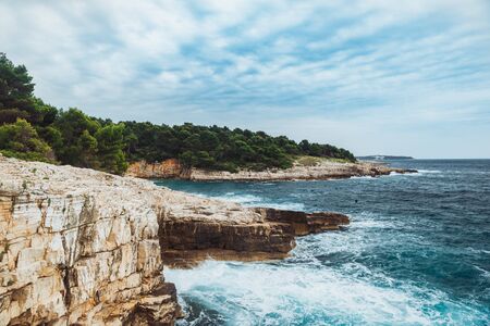 rocky beach with big cliffs stormy weather big waves wallpapersの写真素材
