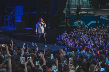 LVIV, UKRAINE - June 18, 2019: rock band singer on stage with microphone crowd around stage shooting on phones. music festのeditorial素材