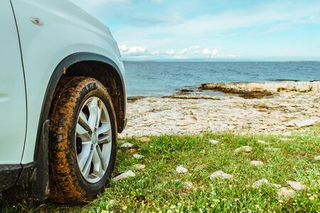 car travel concept suv at seaside with dirty wheels. road trip conceptの写真素材
