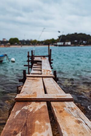 view of small fishing pier with boat near it. overcast weather