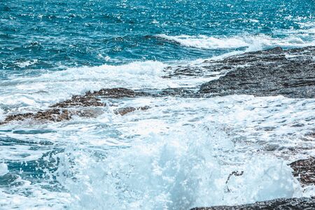 view of rocky seaside waves with white foam. copy spaceの写真素材