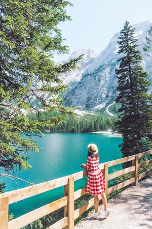 woman standing on the top looking at beautiful lake with mountains summer timeの写真素材