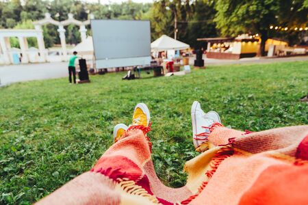 couple covered with blanket watching movie in open air cinema copy spaceの写真素材