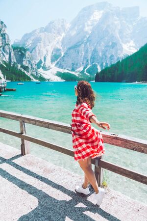 woman standing in front of lake in mountains summer travel conceptの写真素材