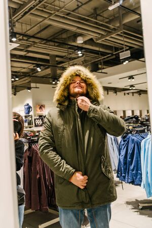 LVIV, UKRAINE - October 27, 2018: man trying on new winter jacket. fashion shopのeditorial素材