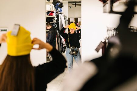 LVIV, UKRAINE - October 27, 2018: woman trying on new cap in store. lifestyleのeditorial素材