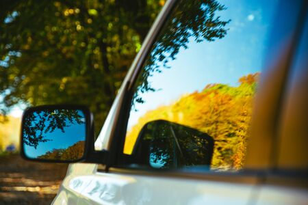 car close up reflection of yellow trees in mirror road tripの写真素材