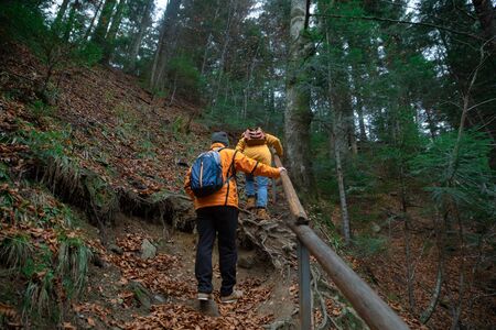 couple friends hiking by forest mountains autumn season