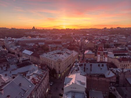 Lviv, Ukraine - November 11, 2018: aerial view of sunset above old european city car traffic copy...