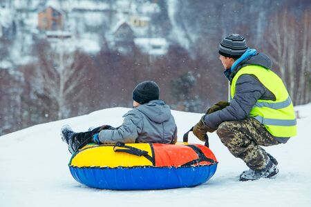 winter fun activities. ride down by hill on snow tubing. pushing