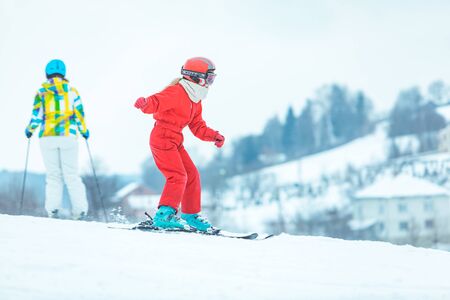 LVIV, UKRAINE - January 12, 2019: boy skiing down by hill in red coat. winter activities.のeditorial素材