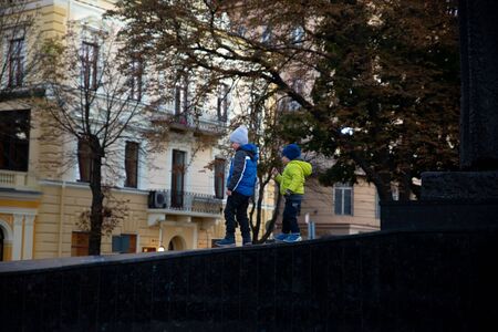 Lviv, Ukraine - September 30, 2018: little boy playing outdoors in autumn clothes at city street
