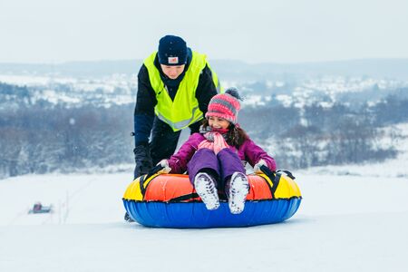LVIV, UKRAINE - January 7, 2019: winter fun activities. ride down by hill on snow tubing. pushingのeditorial素材