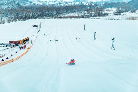 people having fun. snow tubing down by winter hill. winter timeの写真素材